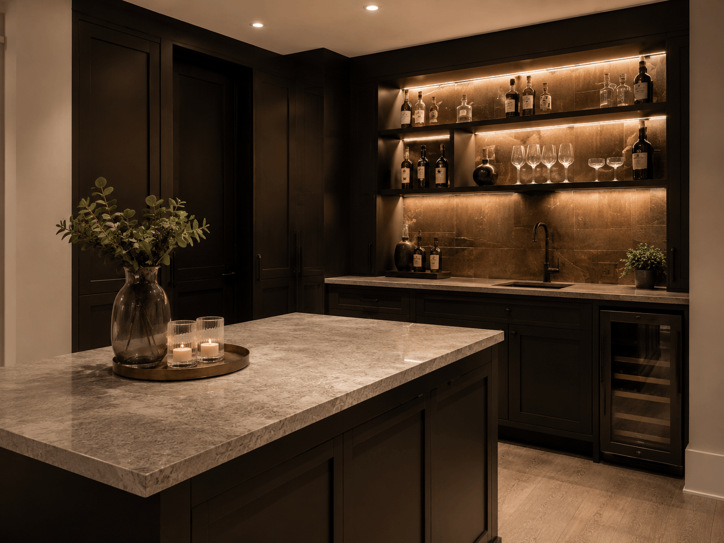 Finished basement bar with dark cabinetry, stone counter, and warm shelf lighting
