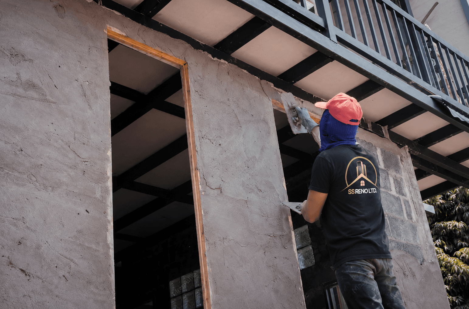 SS RENO LTD. crew working on an exterior concrete surface near a covered structure